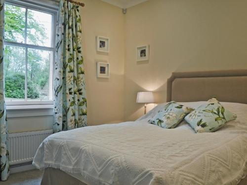 a bedroom with a bed with two pillows and a window at Fernwoodlea in Blairhall