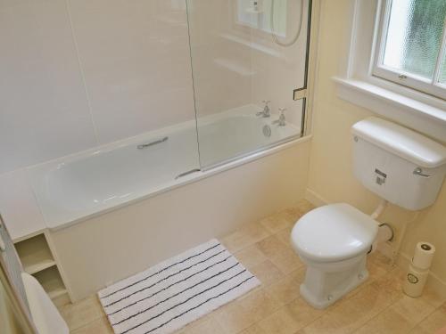 a bathroom with a shower and a toilet and a tub at Fernwoodlea in Blairhall