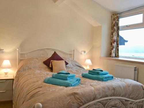 a bedroom with a bed with blue towels on it at Yr Hen Sgubor in Pentre-briwnant
