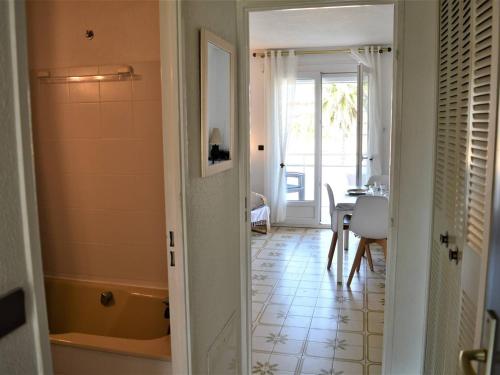 un couloir avec une chambre avec une baignoire et une table dans l'établissement Appartement PMR 2 pièces, clim, garage, proche plages et commerces - FR-1-226B-36, à Cavalaire-sur-Mer