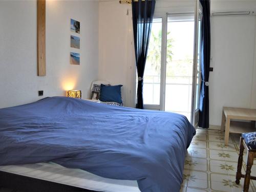 une chambre avec un lit bleu et une fenêtre dans l'établissement Appartement PMR 2 pièces, clim, garage, proche plages et commerces - FR-1-226B-36, à Cavalaire-sur-Mer