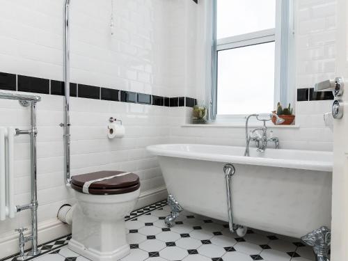 a white bathroom with a tub and a toilet at The Beach House in Weston-super-Mare