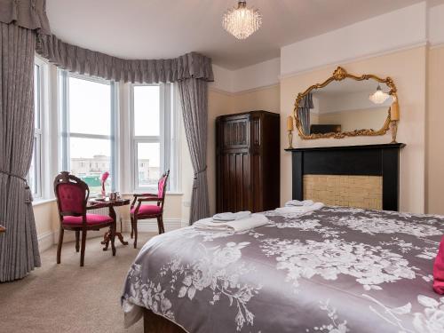 a bedroom with a large bed and a mirror at The Beach House in Weston-super-Mare