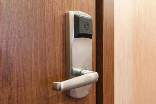 a silver door handle on a wooden door at Best Western Plus Astana Hotel in Astana