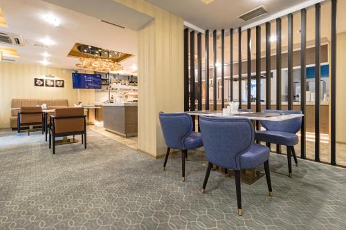 a dining room with blue chairs and a table at Best Western Plus Astana Hotel in Astana