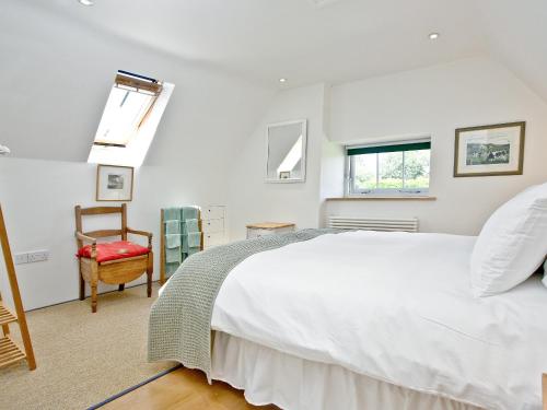 1 dormitorio con 1 cama blanca grande y 1 silla en Antells Farm Barn en Sturminster Newton