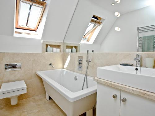 een badkamer met een groot bad en een wastafel bij Antells Farm Barn in Sturminster Newton