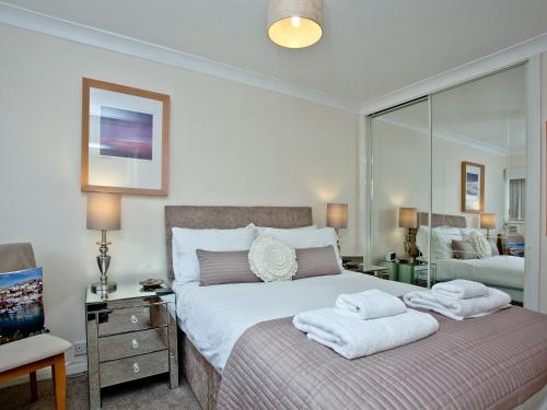 a bedroom with a bed with two towels on it at 3 Linden Court in Brixham