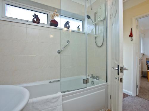 a bathroom with a shower and a tub and a sink at 3 Linden Court in Brixham
