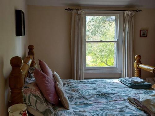 a bedroom with a bed with a large window at Squirrel Cottage in Thornton Dale