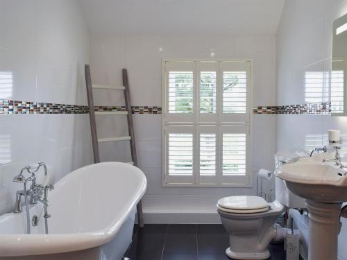 a bathroom with a tub and a toilet and a sink at Fountain Hill in Eglwyswrw