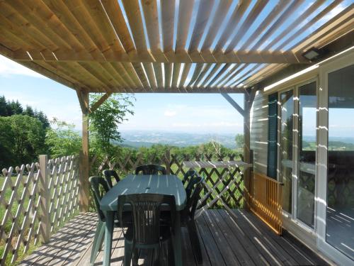 un patio con mesa y sillas en una terraza en Camping le Montbartoux, en Vollore-Ville