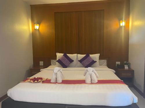 a bedroom with a large bed with towels on it at Embryo Hotel  in Pattaya Central