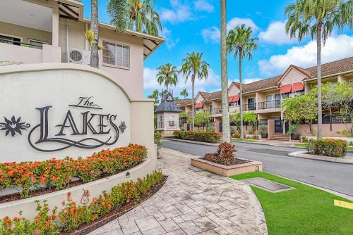 a sign in front of a building with palm trees at Vacanze A Casa - Resort Just Minutes From The CBD in Cairns North