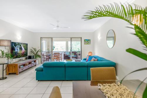 a living room with a blue couch in a room at Vacanze A Casa - Resort Just Minutes From The CBD in Cairns North