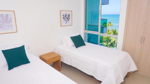 2 camas en una habitación con vistas al océano en Magico Apartamento Frente al Mar 3 Habitaciones AR53, en Coveñas