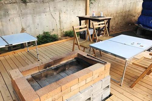 a patio with two tables and a table and chairs at Family Hotel Matsumoto Satoyama Doors in Matsumoto
