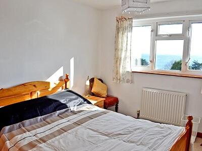 a bedroom with a bed and a window at Ponsgwedhen in Coverack