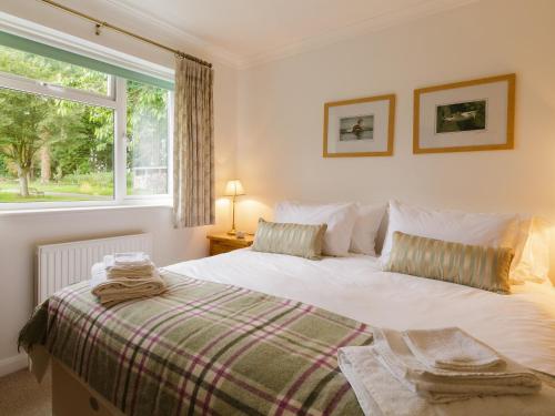 een slaapkamer met een bed en een raam bij Covert Cottage in Gasthorpe