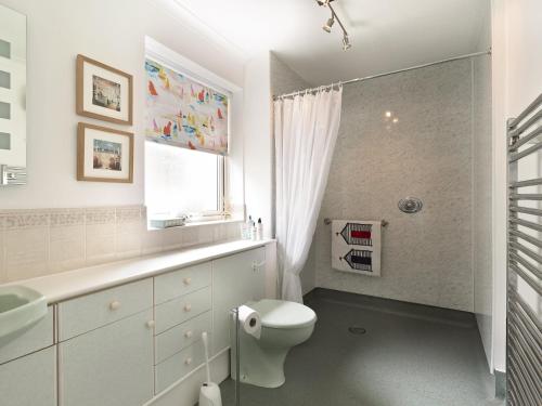 Baño blanco con aseo y lavamanos en Covert Cottage en Gasthorpe