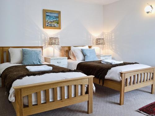 two beds sitting next to each other in a room at Wern Y Wylan Court in Llanddona