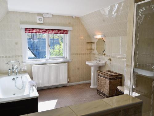a bathroom with a sink and a toilet and a tub at Wern Y Wylan Court in Llanddona