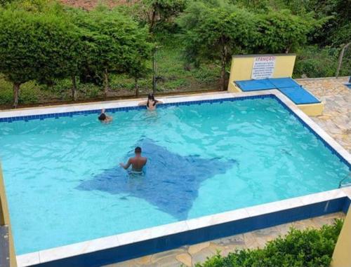 a group of people swimming in a swimming pool at Apartamento Martin de Sá in Caraguatatuba