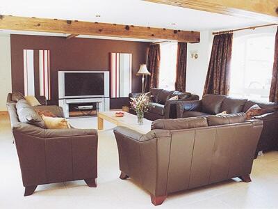 a living room with two couches and a television at The Forge in Somersal Herbert