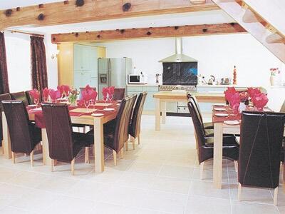a dining room with a table and chairs and a kitchen at The Forge in Somersal Herbert