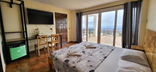 um quarto com uma cama e vista para o oceano em Seaview Mansion Dalaguete Deluxe Apartment 10 em Dalaguete