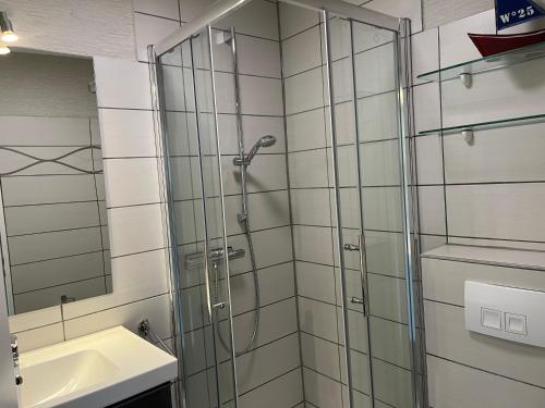 y baño con ducha y lavamanos. en Haus Oland Haus Oland - Wohnung 06 en Südstrand
