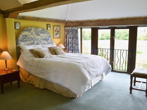 a bedroom with a large bed and a balcony at Oldfield in Warminster