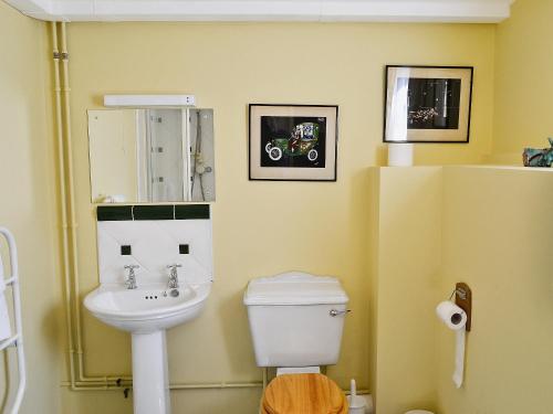 a bathroom with a white toilet and a sink at Oldfield in Warminster