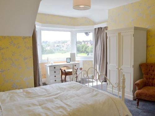 1 dormitorio con cama, ventana y escritorio en South Cliff Sands Ii en Scarborough