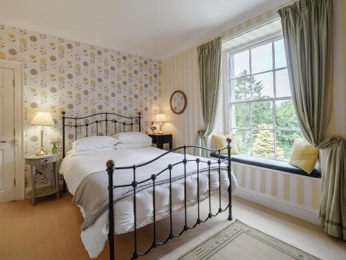 a bedroom with a bed and a window at Holly House in Pooley Bridge