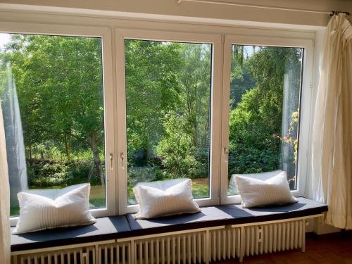 a window seat with white pillows in front of a window at Haus Falkenweg 5 Ferienhaus Falkenweg in Scharbeutz