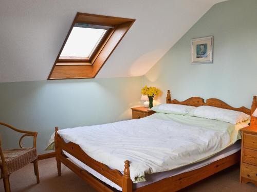 a bedroom with a bed and a window at Eaton Barn in Burmarsh