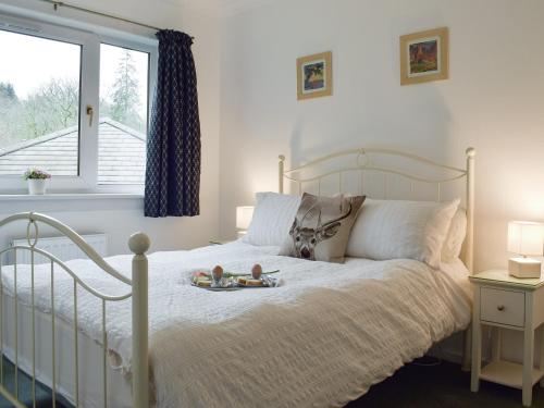 Un dormitorio con una cama con dos muñecas. en Tigh Raineach, en Strathyre
