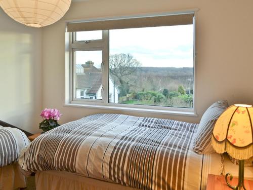 a bedroom with a bed and a large window at Cedars in Fordwich