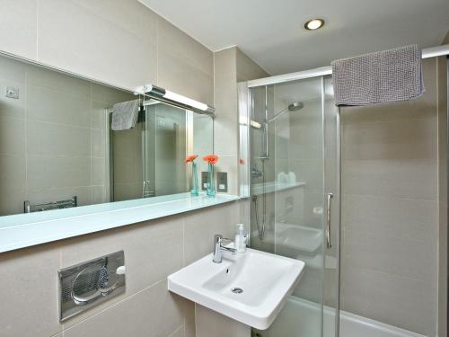La salle de bains est pourvue d'un lavabo et d'une douche. dans l'établissement 4 Ocean Point, à Croyde