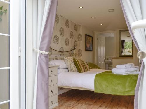 a bedroom with a bed and a mirror at Field View Cottage in Bruisyard