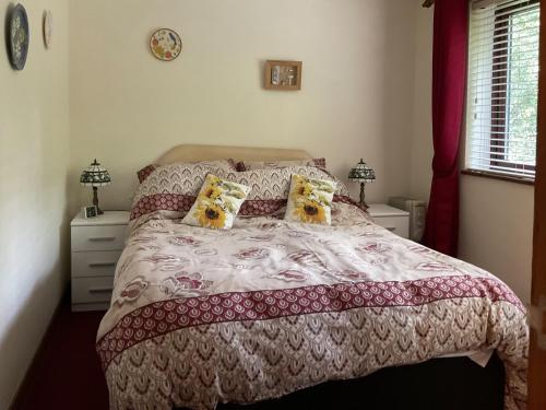 a bedroom with a bed and two lamps and a window at Valley View Annex in Ringwood