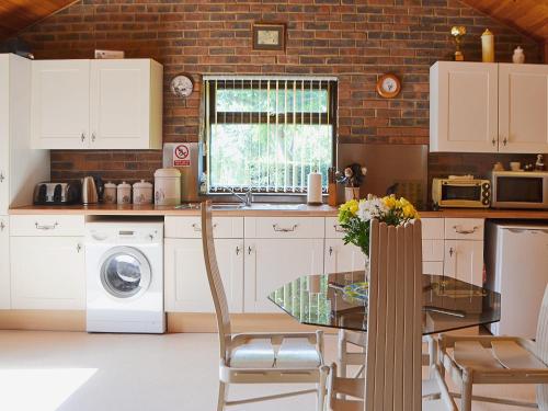 a kitchen with a table and a sink and a washing machine at Valley View Annex in Ringwood