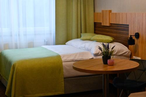 Habitación de hotel con 2 camas y mesa en Zielone Apartamenty z aneksem kuchennym, en Legnica