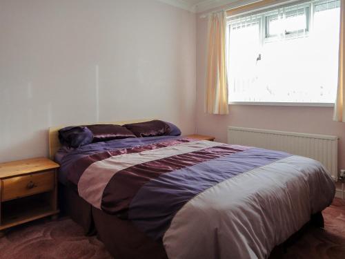 um quarto com uma cama e uma janela em 24 Steed Close em Goodrington