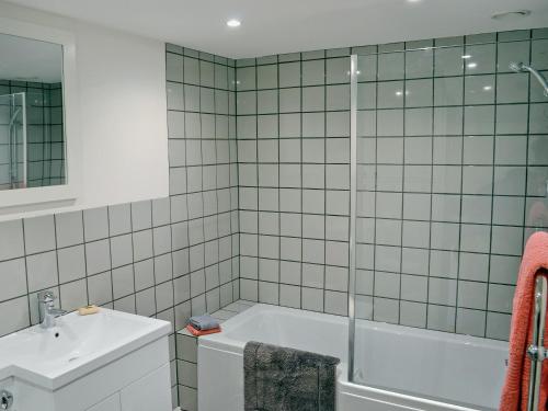 a bathroom with a bath tub and a sink at The Shed With A View in Cadbury