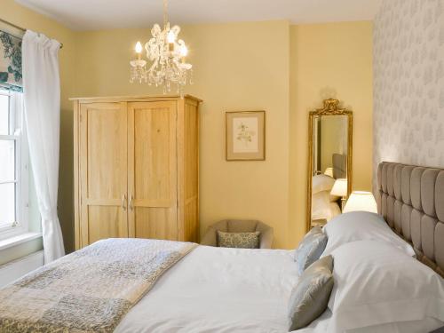 a bedroom with a bed and a chandelier at Trinity House in Ulverston