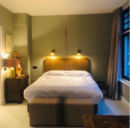 a bedroom with a large bed with a wooden headboard at HOMESTEAD Amsterdam in Amsterdam