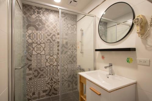 a bathroom with a shower and a sink and a mirror at Kenting Shin Yu Homestay in Kenting