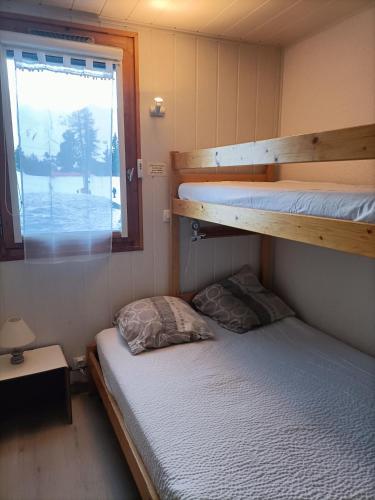 Cette petite chambre dispose de 2 lits superposés et d'une fenêtre. dans l'établissement Appartement 5 pers Plagne village, à La Plagne